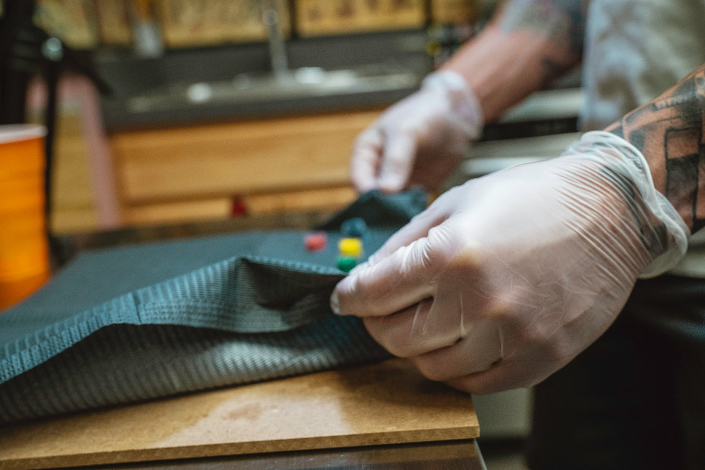 Vinyl Disposable Gloves showcased on a tattoo artist's hands setting up his station