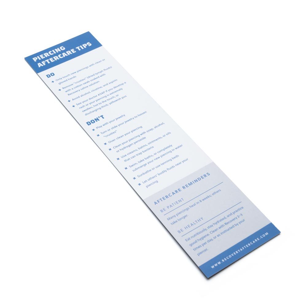 Back of piercing aftercare paper insert with tips on white background