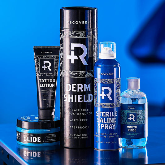 Collection of Recovery tattoo aftercare products, including Derm Shield, tattoo lotion, and saline spray.
