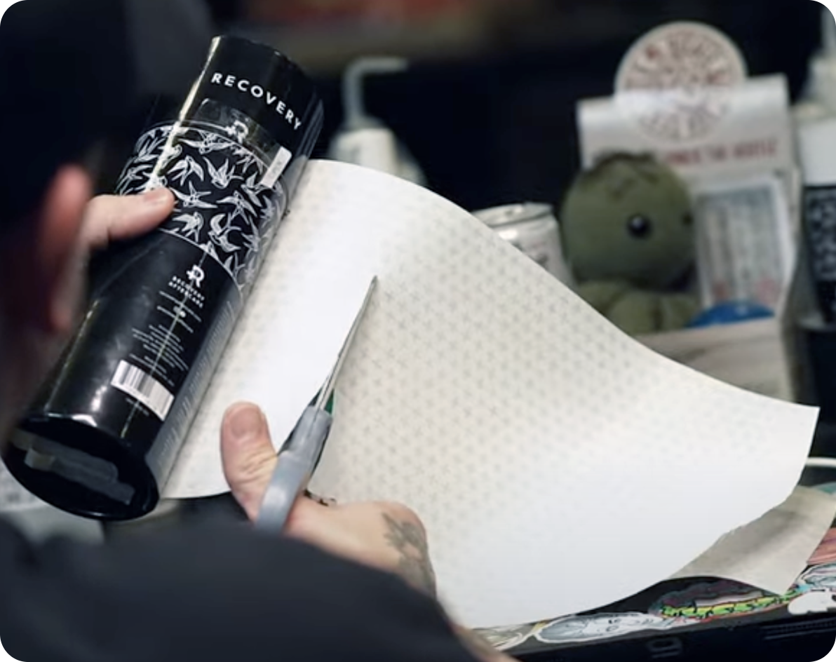 Cut the Derm Shield to cover tattooed area plus a 1”–2” margin from the edge of the tattoo.