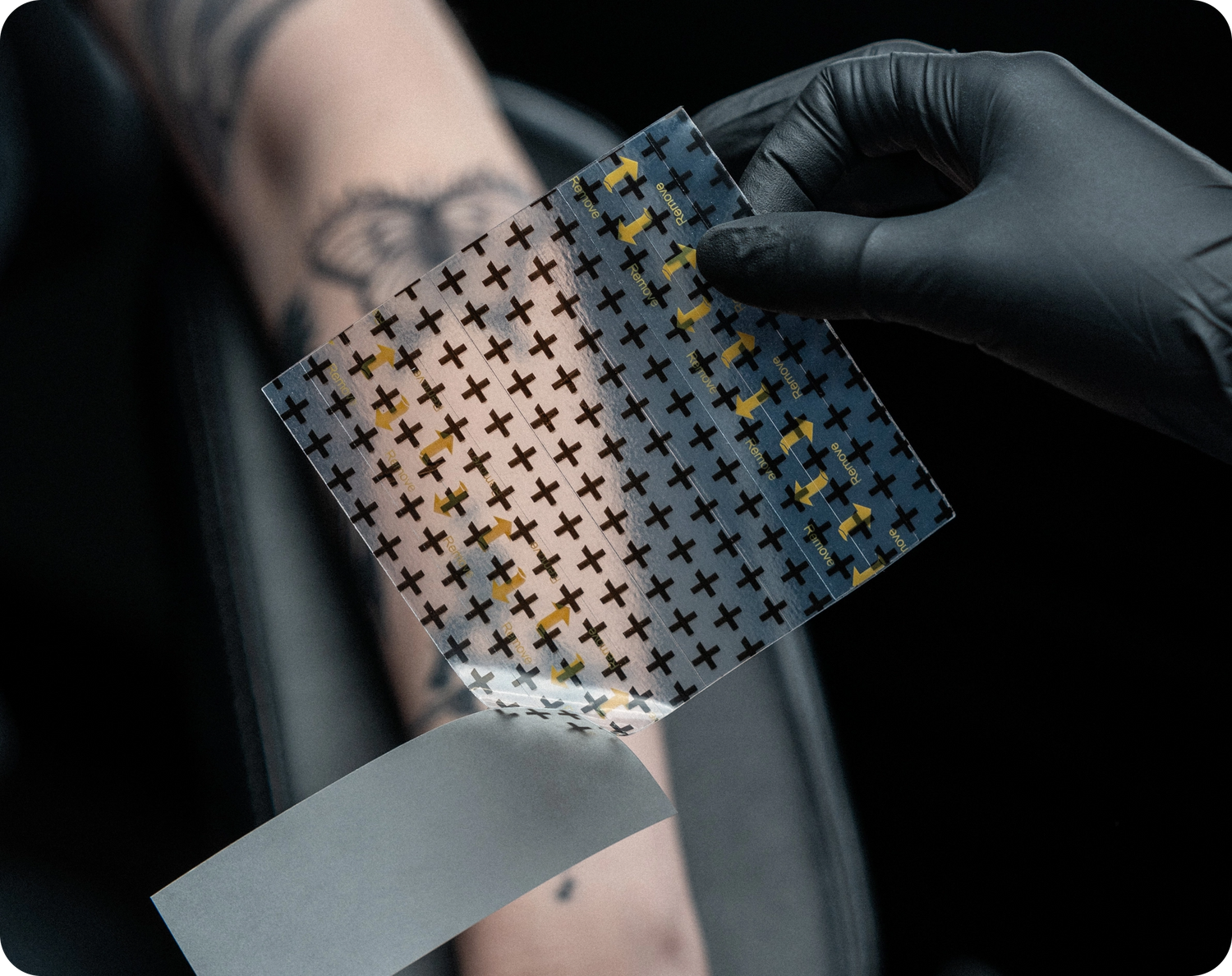 Peel off backing and position the Derm Shield over tattoo with the adhesive side facing the skin.