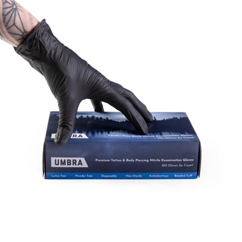 Umbra Nitrile Gloves with a gloved hand holding the box