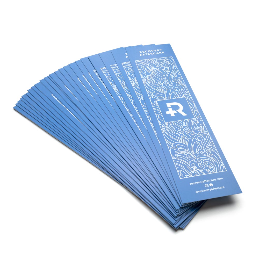 Stack of piercing aftercare insert cards fanned out on white background